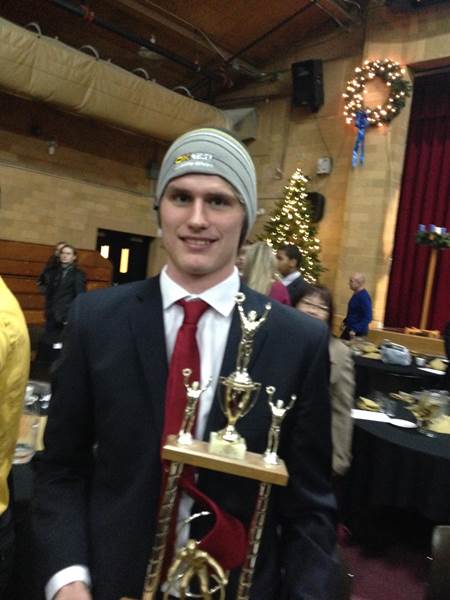 Ok Tire & Auto Service owners' son with trophy during holidays
